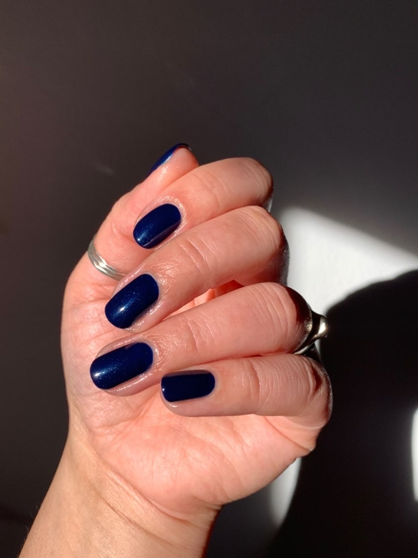AI generated Glamour woman hand with navy blue nail polish on her  fingernails. Navy nail manicure with gel polish at luxury beauty salon. Nail  art and design. Female hand model. French manicure.